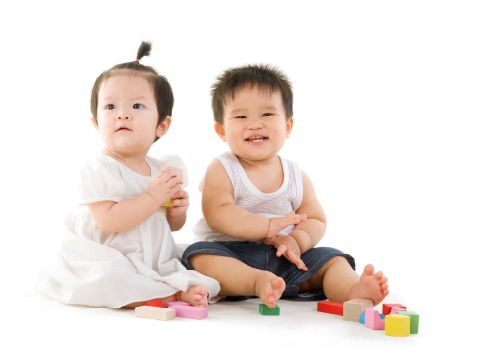 Bé trai và bé gái cùng chơi đồ chơi